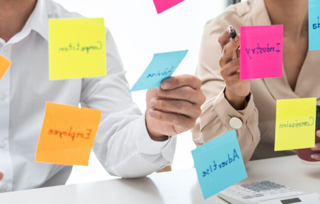 Business people holding similar keyword Post-Its Business people holding similar keyword Post-Its