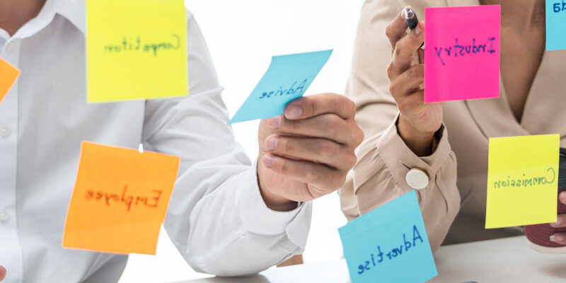 Business people holding similar keyword Post-Its Business people holding similar keyword Post-Its