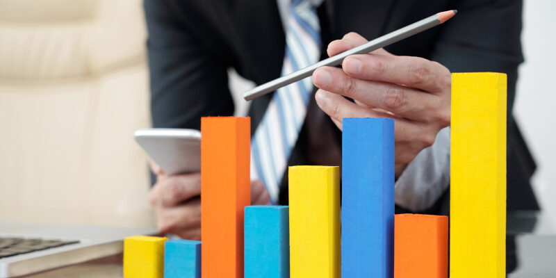 Improving Sales Chart Man analyzes a symbolic sales chart.