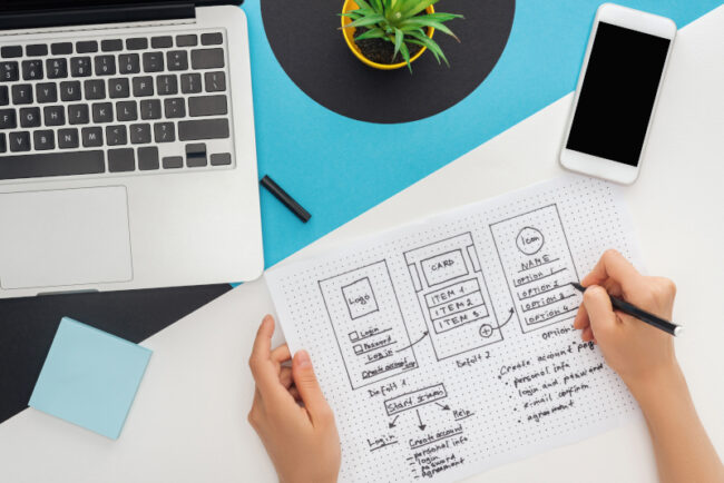 Cropped view of a woman’s hands mapping out a Kalamazoo web design. Hands drawing out a Kalamazoo web design