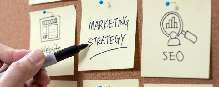 A hand writing notes to create an Internet marketing strategy.