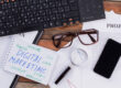 A keyboard and notepad working out what digital marketing is.