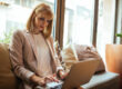 A woman sitting on her couch blogging