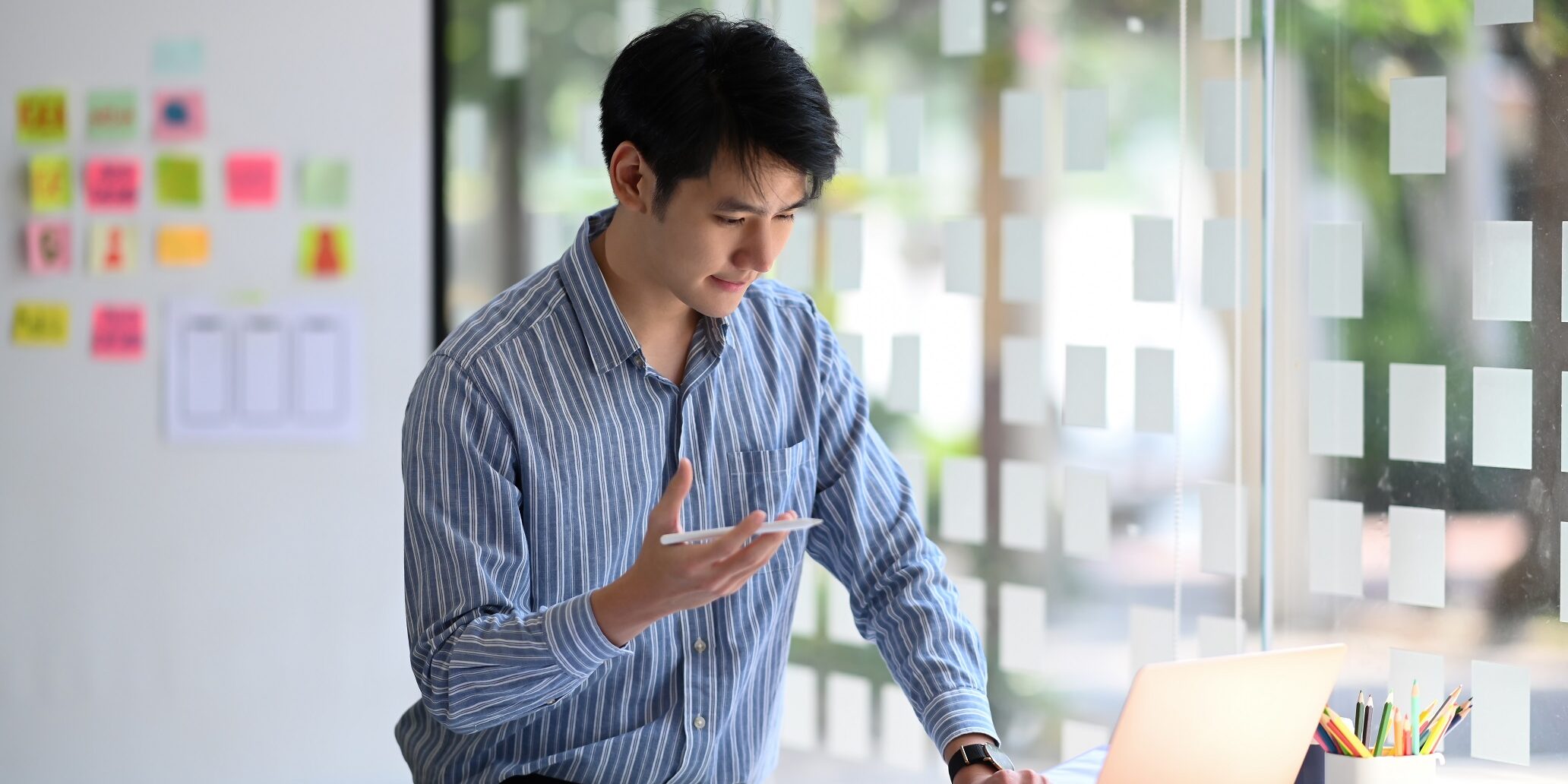 Creative male web designer planning application development for web mobile phone at modern workplace.