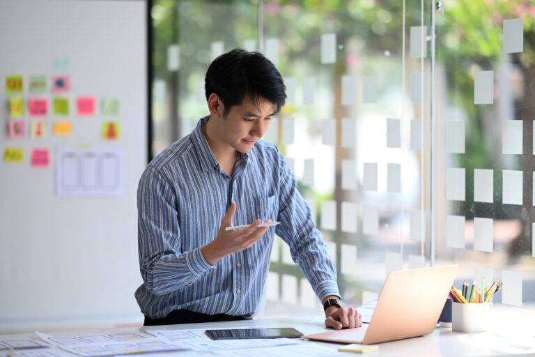 Creative male web designer planning application development for web mobile phone at modern workplace.