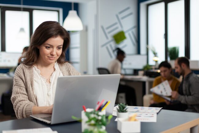 Close up of satisfied businesswoman answering email Woman working on an email marketing campaign in an office setting.